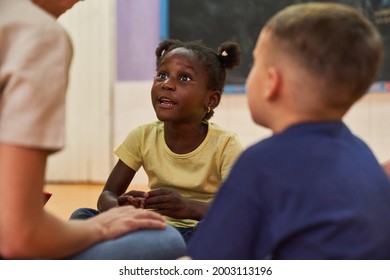 African Girl Talks To Daycare Worker Or Childminder In International Kindergarten