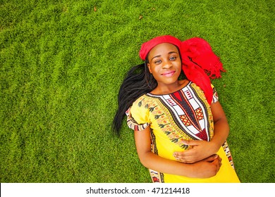 African girl in traditional wear on a grass