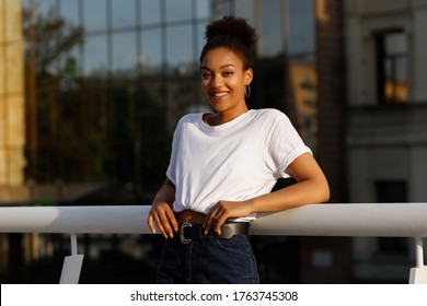 African girl in white T-shirt smiles in summer - Shutterstock ID 1763745308