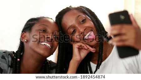 Similar – Sisters, teenage girl and her younger sister pushing hay bale playing together outdoors in the countryside