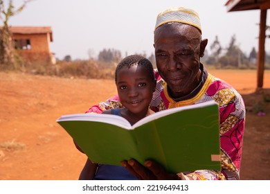 African Grand Father Educating His Grandson Outdoor Under The Sun. Education Concept.