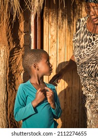 African Granny Giving Advice To Her Granddaughter In Front Of The House