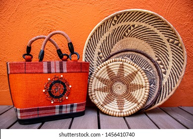 African Grass Baskets With An Orange African Handbag On An Orange Background 