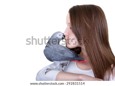 African gray parrot sitting on a girls hand  and kissing her on the lips. Isolated on white.