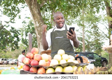 An African Grocery Seller Using His Phone