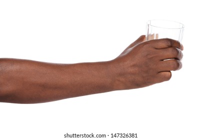 African Hand Holding Out A Clear Glass Of Water.