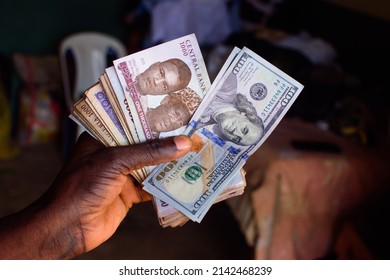 African Hands Holding Multiple Spread Nigerian Currency, Money Or Cash With A Two Notes Of American Hundred Dollar Placed Them