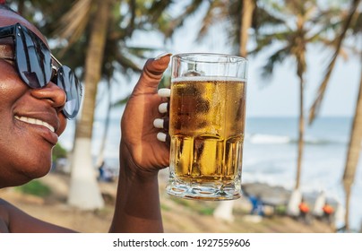 African happy woman drinking a beer out at a beach bar in Accra Ghana