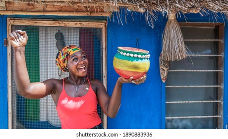 African happy woman with a pot in her hand waiting for rain in the dry season in Ghana