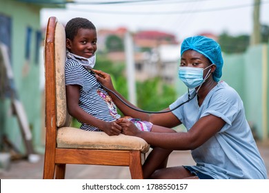 African health worker wearing a surgical face mask and child wearing homemade mask for protection,auscultating child chest,both looking at camera-concept on child health in covid-19 pandemic - Shutterstock ID 1788550157