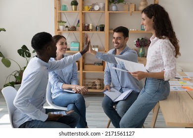 African and Hispanic male colleagues, buddies, ambitious teammates find solution, make agreement give high five take part in group meeting with diverse staff. Teamwork workflow, share success concept