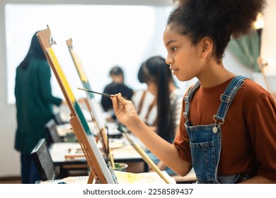 African kid drawing in classroom, young girl happy funny study and play painting acrylic color on canvas.Group of  children drawing with  teacher in school studio. - Powered by Shutterstock
