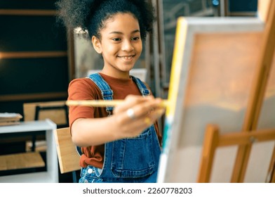 African kid drawing in classroom, young girl happy funny study and play painting acrylic color on canvas.Group of  children drawing with  teacher in school studio. - Powered by Shutterstock