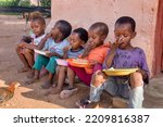 african kids eating some sorghum porridge, village in botswana