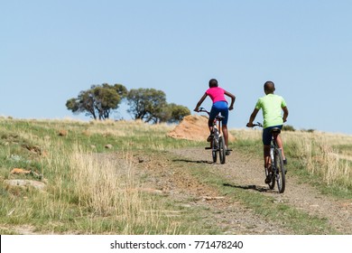 African Kids On A Bicycle. Children Riding A Bike. Rural Adventure. Kids In An African Village. Black Boy. African Girl.