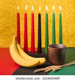 African Kwanzaa holiday concept with traditional lit candles, banana, bowl and ears of wheat  - Powered by Shutterstock