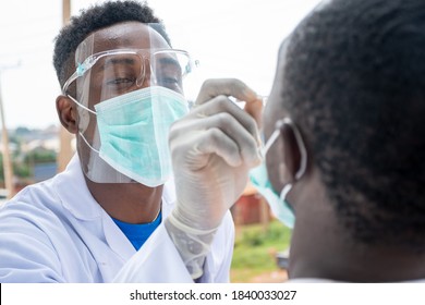 an african lab scientist taking nasal sample from a man