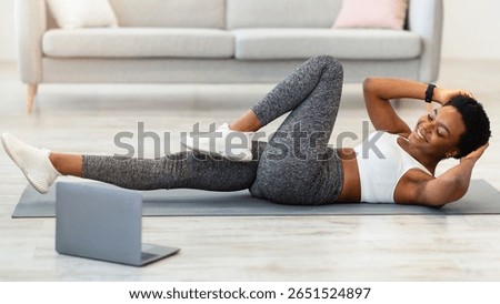 African Lady Doing Abs Exercise At Laptop Training At Home