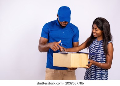 African Lady Receiving A Package From A Delivery Worker, Signing The Manifest