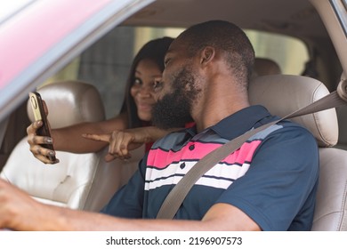 african lady showing a driver directions on her phone - Shutterstock ID 2196907573