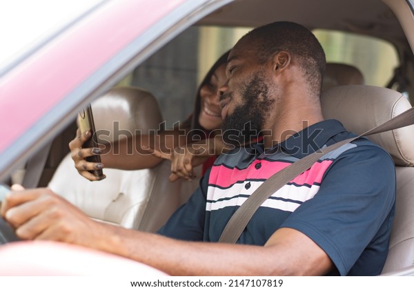 african\
lady showing a driver directions on her\
phone