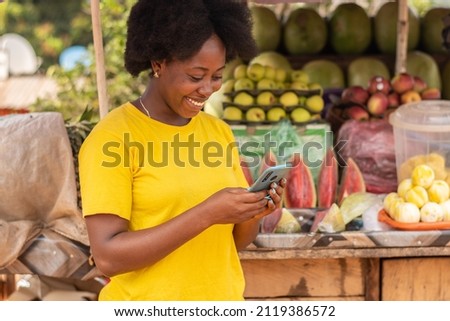 african lady using her phone in market