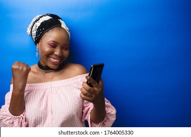 An African Lady Viewing Her Phone. Side View