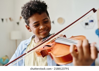 African little boy playing violin at home