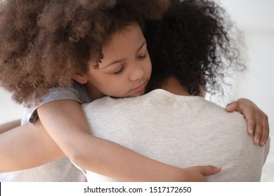 African little daughter embracing mommy rear back close up view, adopted child showing gratitude to new mother, concept of ask forgiveness say sorry, give support to mama in difficult moment of life