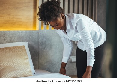 African maid making bed in hotel room. Staff Maid Making Bed. African housekeeper making bed. Maid working at a hotel making the bed. Housekeeper cleaning a hotel room