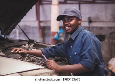 African maintenance male checking car, service via insurance system at automobile repair and check up center