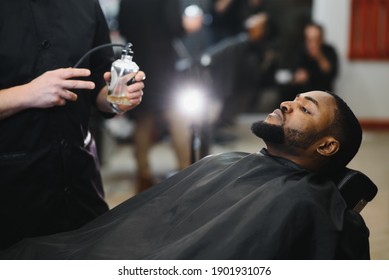 African Male Client Getting Haircut At Barber Shop From Professional Hairstylist.