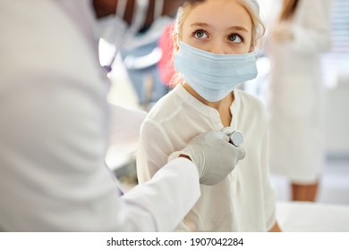 African Male Doctor Checking Heartbeat Of Kid Girl Using Stethoscope, In Hospital Room. Close-up Portrait Of Child Looking Up At Doctor