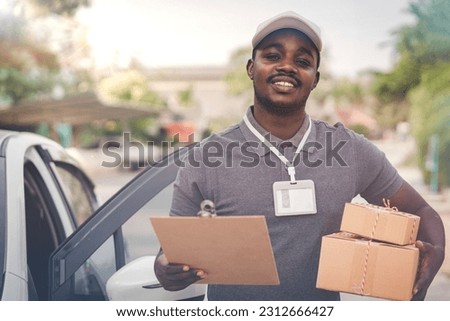 African male postal delivery courier man holding delivering package boxs and cardboard