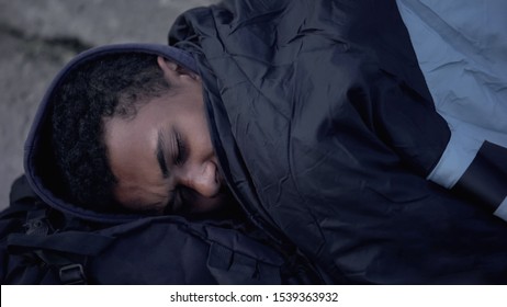 African Male Refugee Lying Street Ground Covered With Sleeping Bag, Homelessness