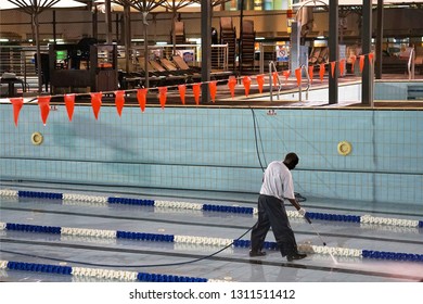 African Male Staff Pool Cleaning Hotel At Night. 16 September 2017. Tel Aviv. Israel.