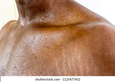 African Male sweaty torso with stretch marks Close up of sweat building up in a Black man’s body after hard work isolated on white background