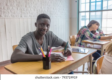 African male teenager making lesson in the classroom and happy about the test. - Powered by Shutterstock