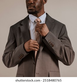 African man adjusting tie, business attire studio shoot, professional business person, confident man in leadership role, professional dress and attire - Powered by Shutterstock