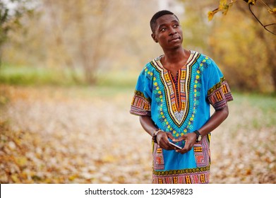 African Man In Africa Traditional Shirt On Autumn Park.