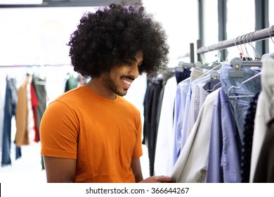 African Man With Afro Looking For Clothes In Store