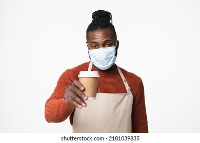 African Man Barista Bartender Barman In Apron Wearing Face Mask Against Coronavirus Covid 19 Selling Making Coffee Cup Hot Beverage For Take Away Isolated In White Background