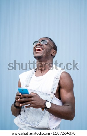 African man blue background with mobile phone.