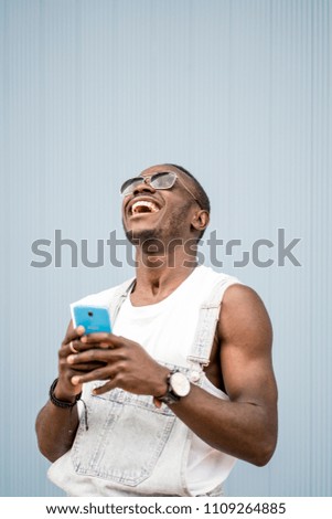 Similar – African man blue background with mobile phone.