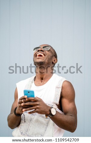 Similar – African man blue background with mobile phone.