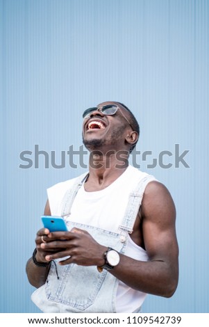 Similar – African man blue background with mobile phone.