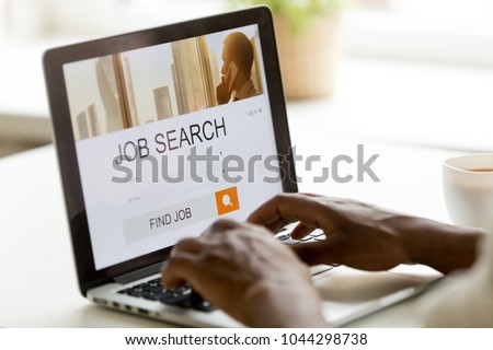 African man browsing work opportunities online using job search computer app, black jobless seeker looking for new vacancies on website page at laptop screen, recruitment concept, rear close up view