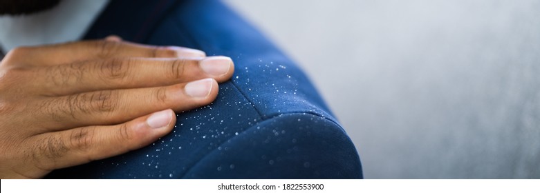 African Man Brushing Dandruff From Dirty Suit