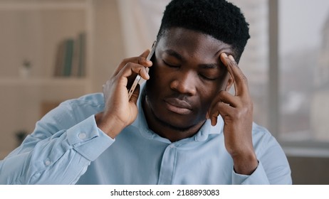 African man businessman american male employee worker answer incoming call talking on phone in home office disappointed frustrated young guy receiving bad news failed transaction negative