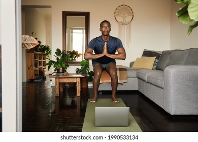 African Man In The Chair Pose During An Online Yoga Class